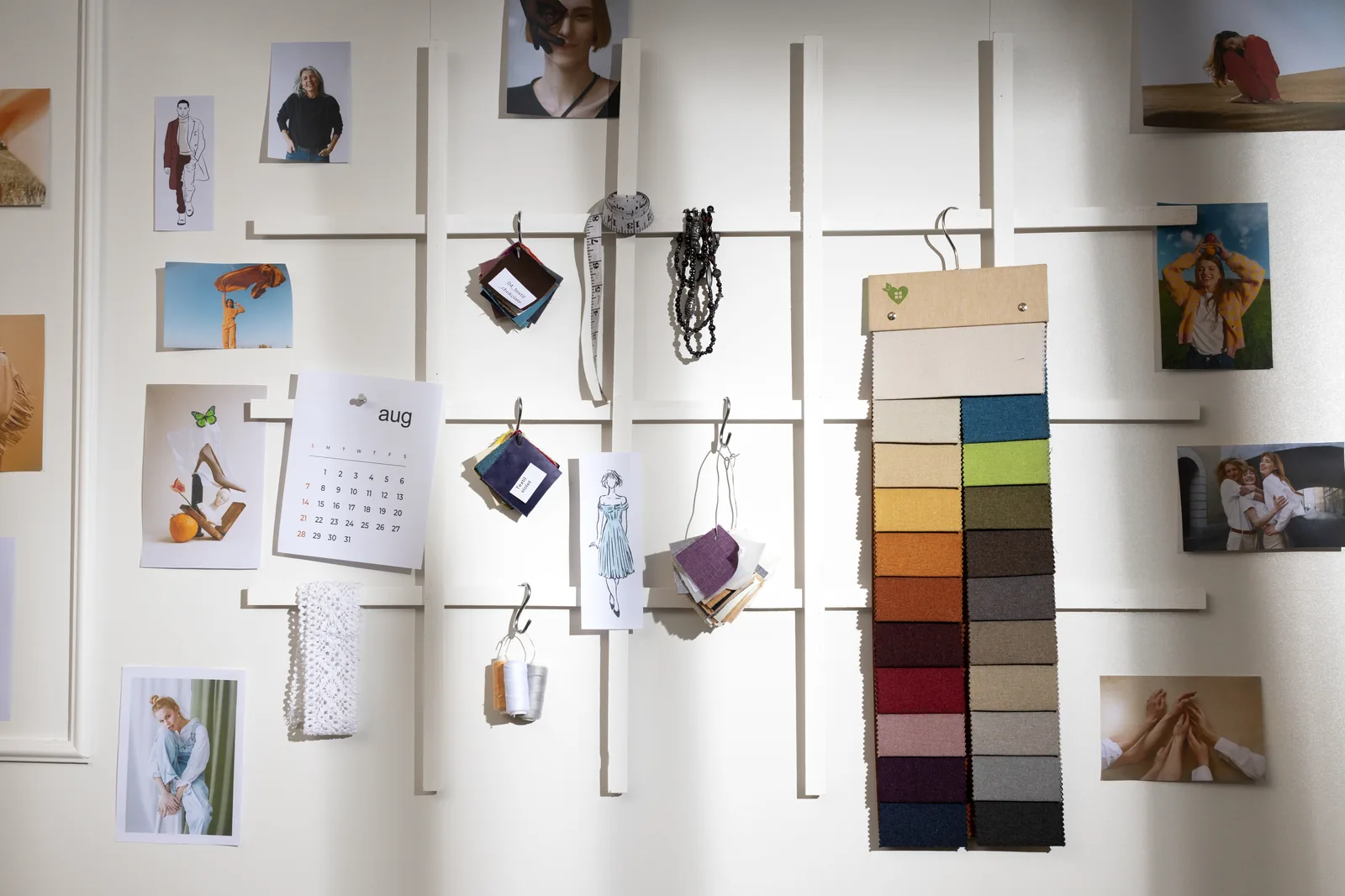 Ściana z moodboardem: zdjęcia, próbki materiałów i palety kolorów w pracowni projektowej